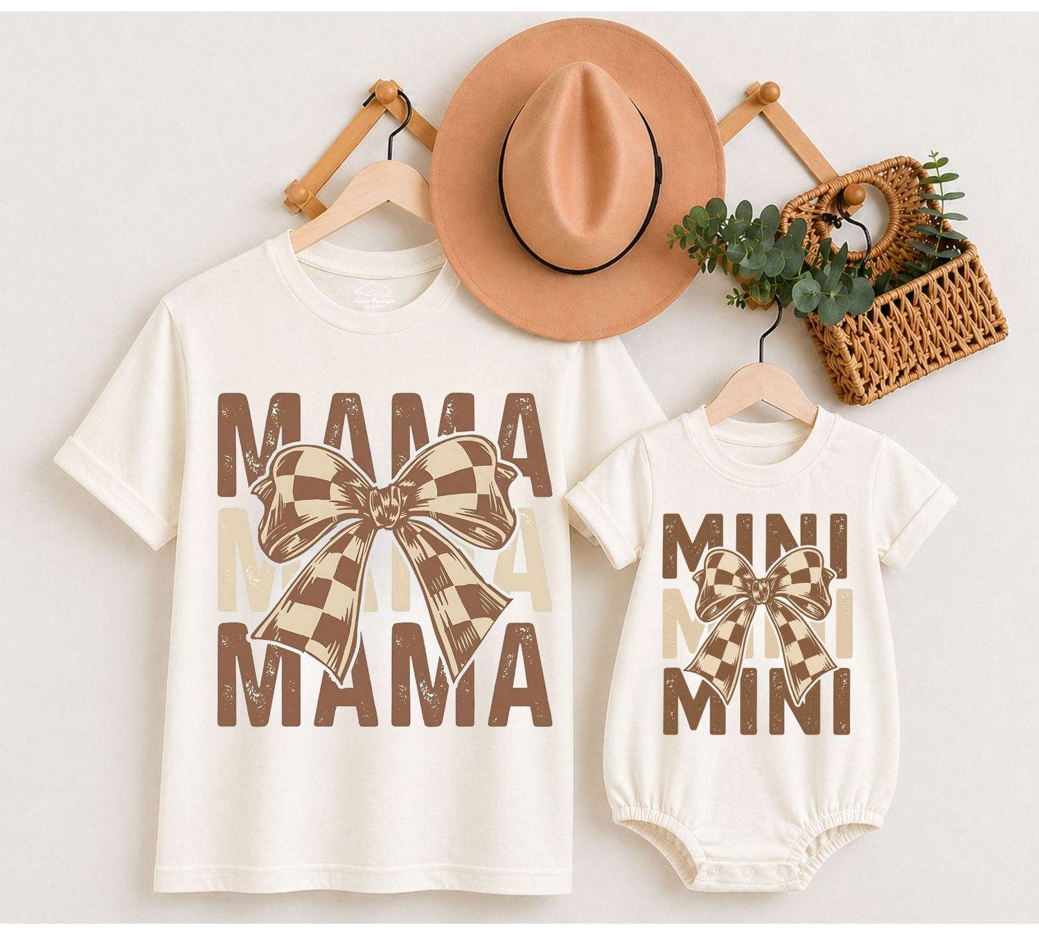 A matching mother-and-child t-shirt and bodysuit set in cream, featuring brown and beige plaid bow graphics and the words &